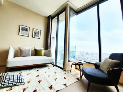 Modern living room with panoramic city view, stylish furniture, and elegant decor in a high-rise apartment.