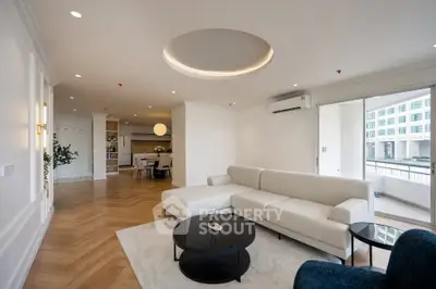 Spacious modern living room with elegant decor and large windows offering natural light.