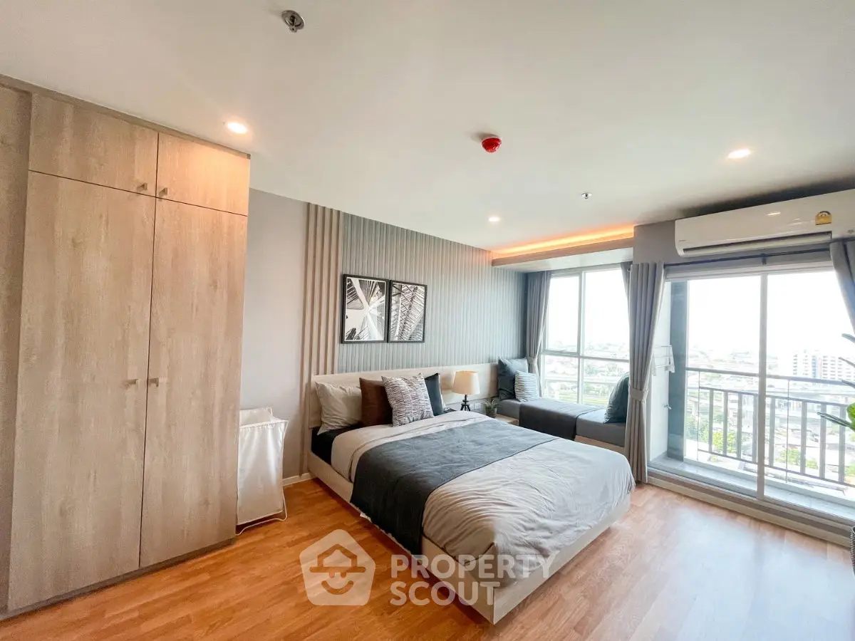 Spacious modern bedroom with large windows and city view, featuring stylish decor and ample natural light.