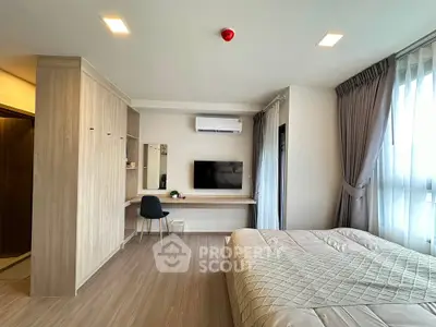 Modern bedroom with stylish decor, featuring a wall-mounted TV and sleek workspace.