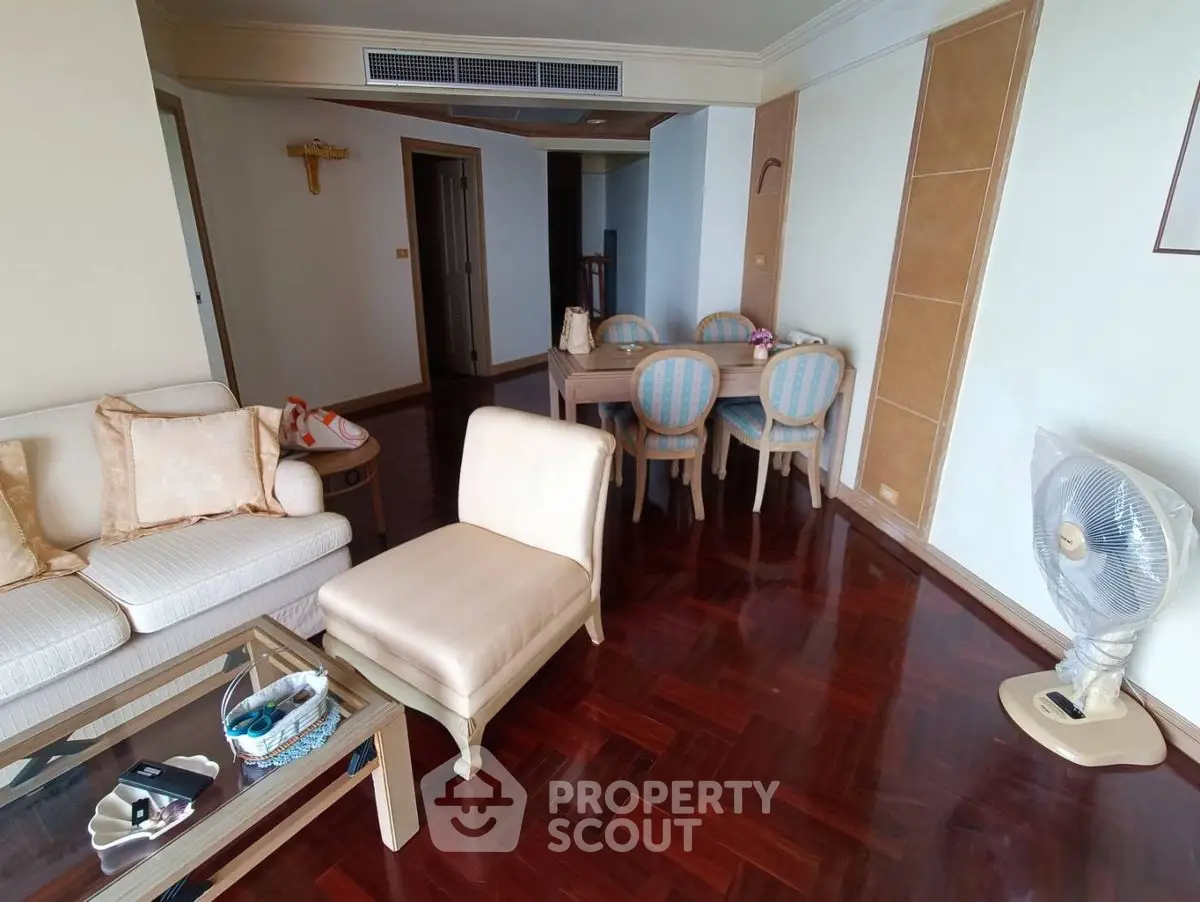 Spacious living room with elegant dining area and polished wooden floors