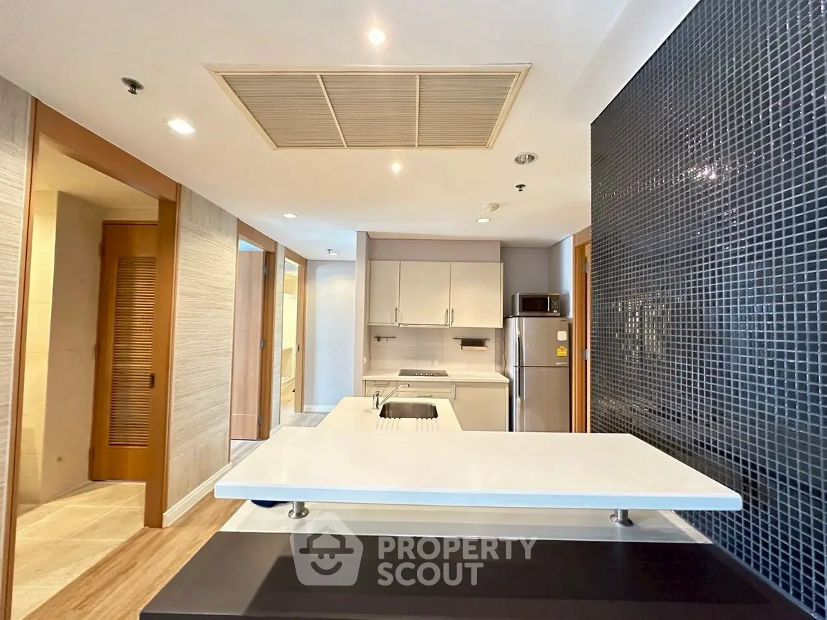 Modern kitchen with sleek design and open layout, featuring a stylish backsplash and integrated appliances.