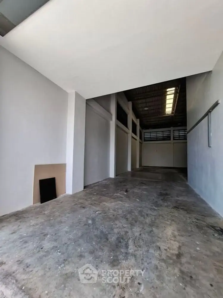 Spacious industrial-style storage area with high ceilings and concrete flooring.