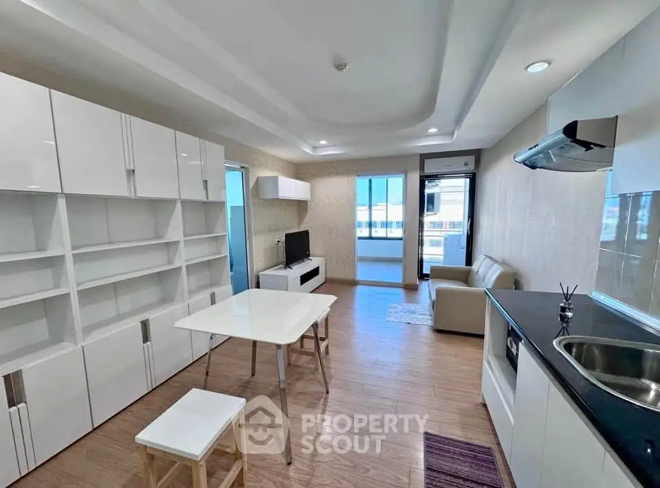 Modern open-layout living room with sleek kitchen and stylish furnishings.
