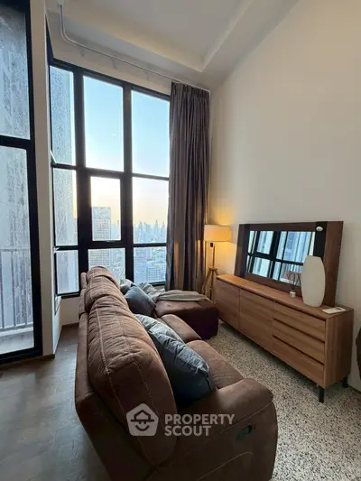 Modern living room with large windows and city view, featuring stylish furniture and warm lighting.