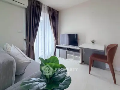 Modern living room with cozy sofa, TV, and elegant curtains in a bright apartment.