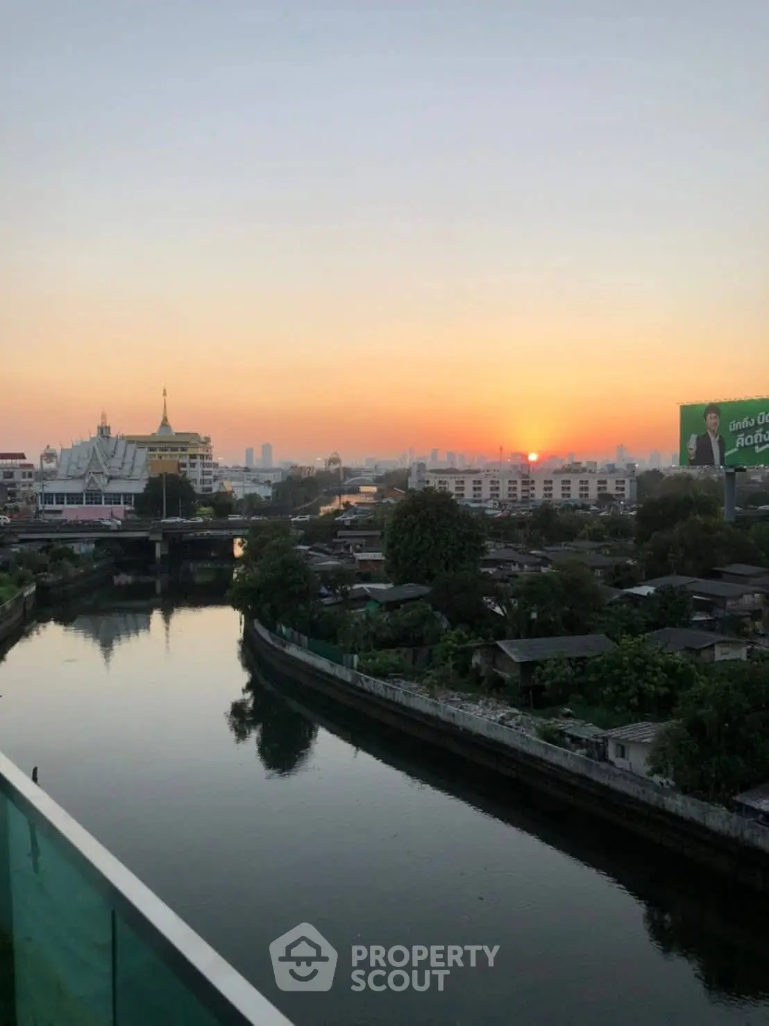 Stunning sunset view over a serene river with city skyline in the background, perfect for urban living.
