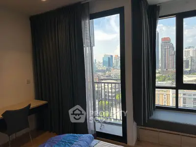 Modern bedroom with city view and large windows in high-rise apartment