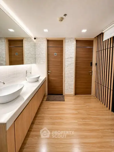 Modern bathroom with stylish sinks and wooden accents, perfect for a contemporary home.