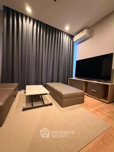 Modern living room with sleek furniture and large TV, featuring elegant lighting and stylish decor.