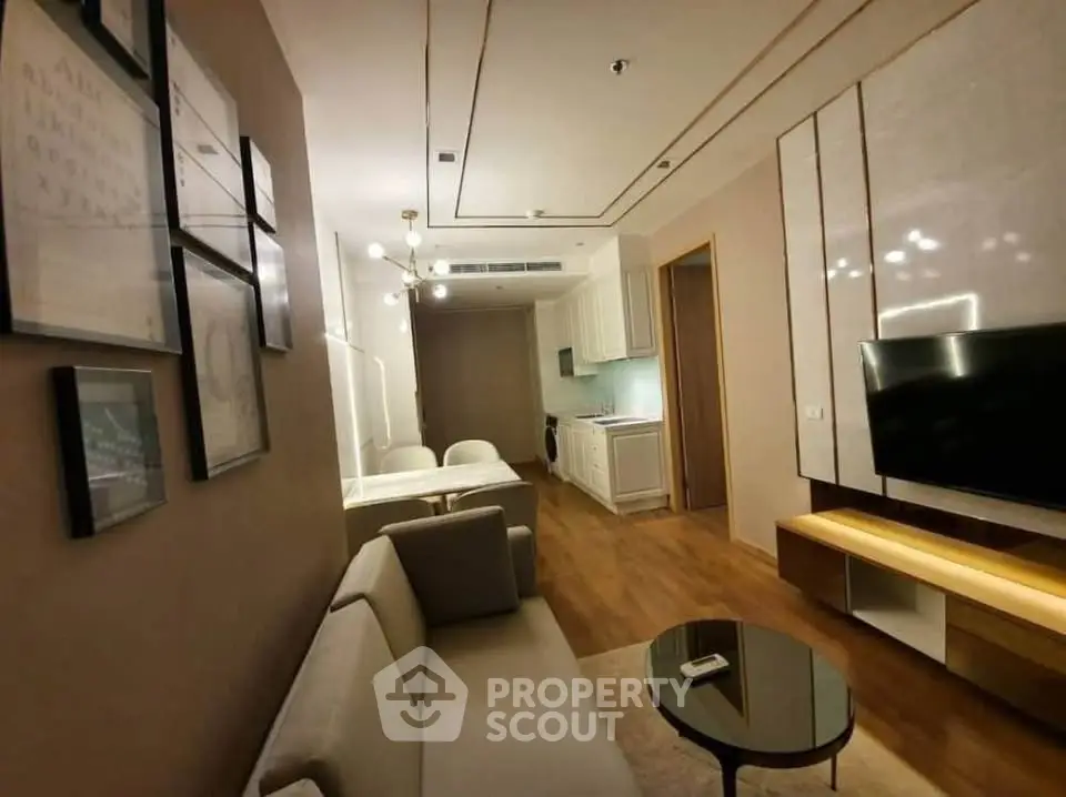 Modern living room with elegant decor and open kitchen layout, featuring cozy seating and stylish lighting.