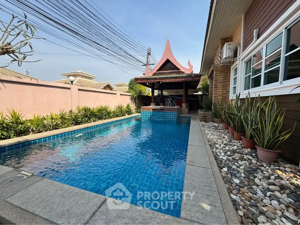 Stunning poolside view with traditional gazebo and lush garden landscaping.
