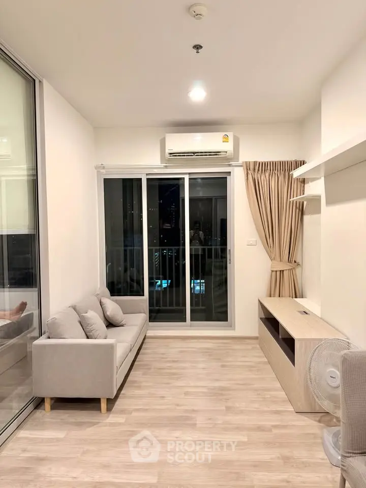 Modern living room with balcony access and air conditioning in a stylish apartment.