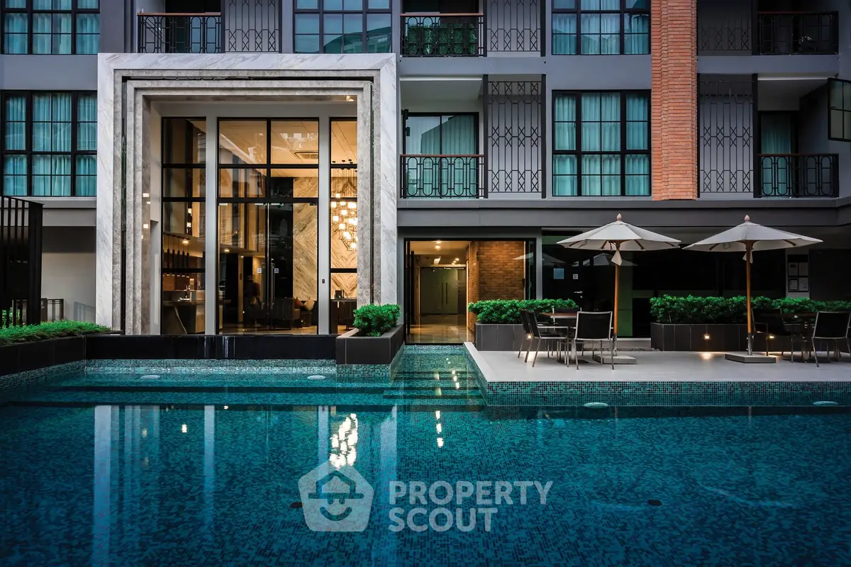 Luxurious modern building exterior with inviting pool and stylish seating area.