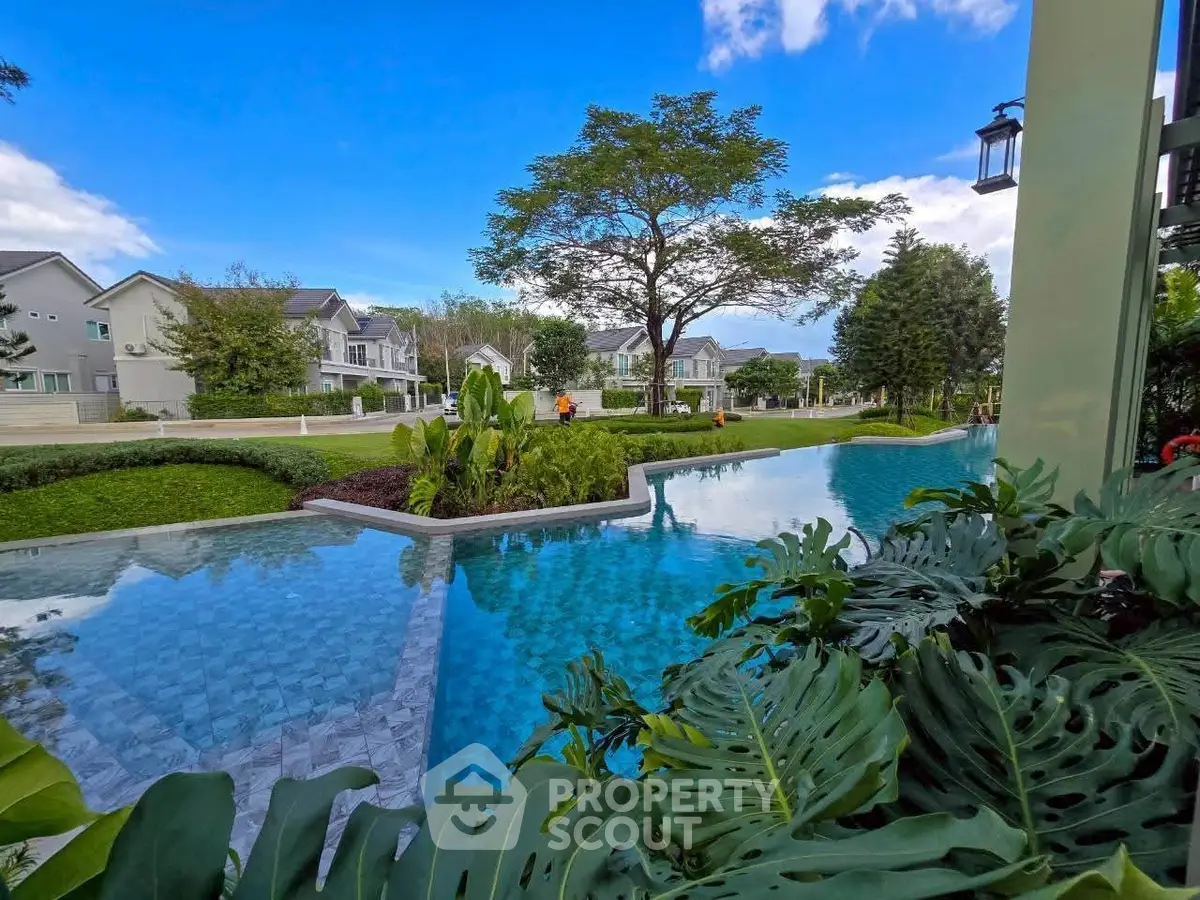 Luxurious residential community with stunning pool and lush greenery, perfect for serene living.