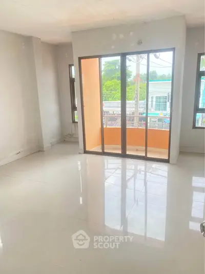 Bright empty room with large windows and balcony access, ideal for customization.
