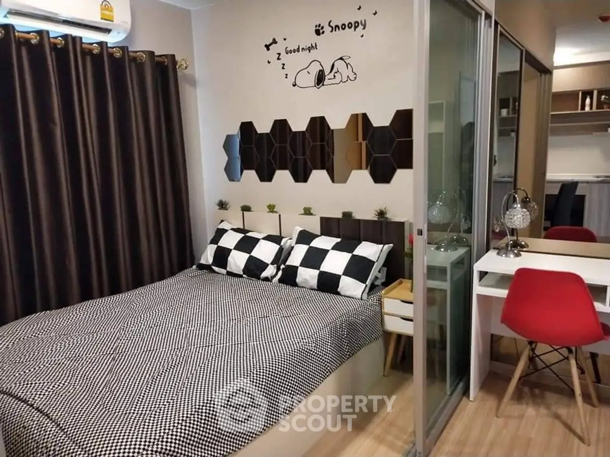 Cozy bedroom with stylish decor and workspace, perfect for modern living.