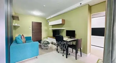 Modern living room with stylish furniture and workspace in a cozy apartment.