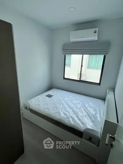 Cozy minimalist bedroom with air conditioning and natural light