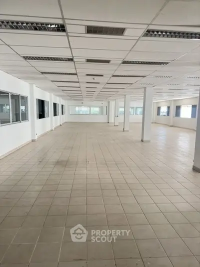 Spacious open-plan commercial space with tiled flooring and ample natural light.