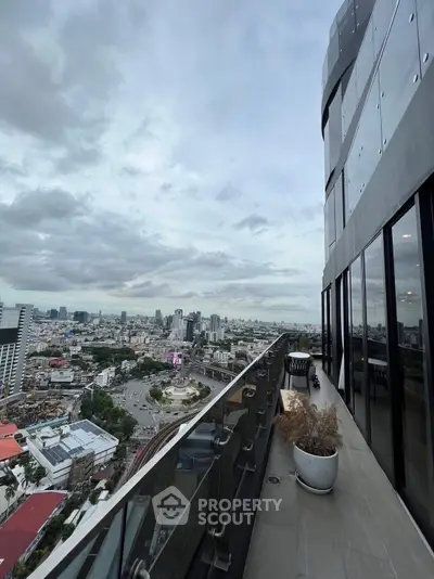 Stunning high-rise balcony with panoramic city views and modern glass railing.