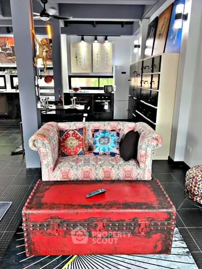 Stylish living room with colorful sofa and vintage red trunk coffee table