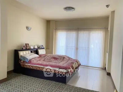 Spacious bedroom with large window and cozy bed setup