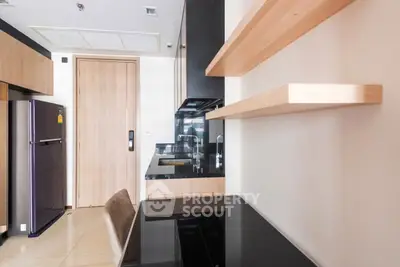 Modern kitchen with sleek black countertops and wooden shelving