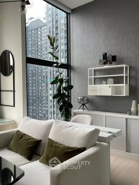 Modern living room with large windows and city view, featuring stylish decor and comfortable seating.