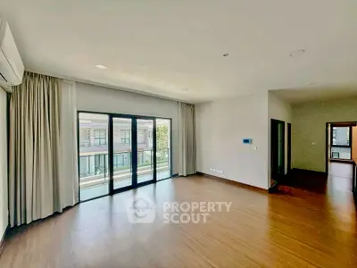 Spacious living room with large windows and wooden flooring in modern apartment