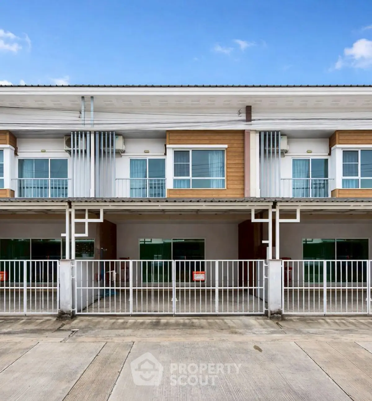 Modern townhouse exterior with gated parking and large windows