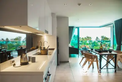 Modern open-layout kitchen and dining area with scenic balcony view