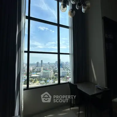 Stunning city view from a modern high-rise apartment with large windows and elegant dining area.