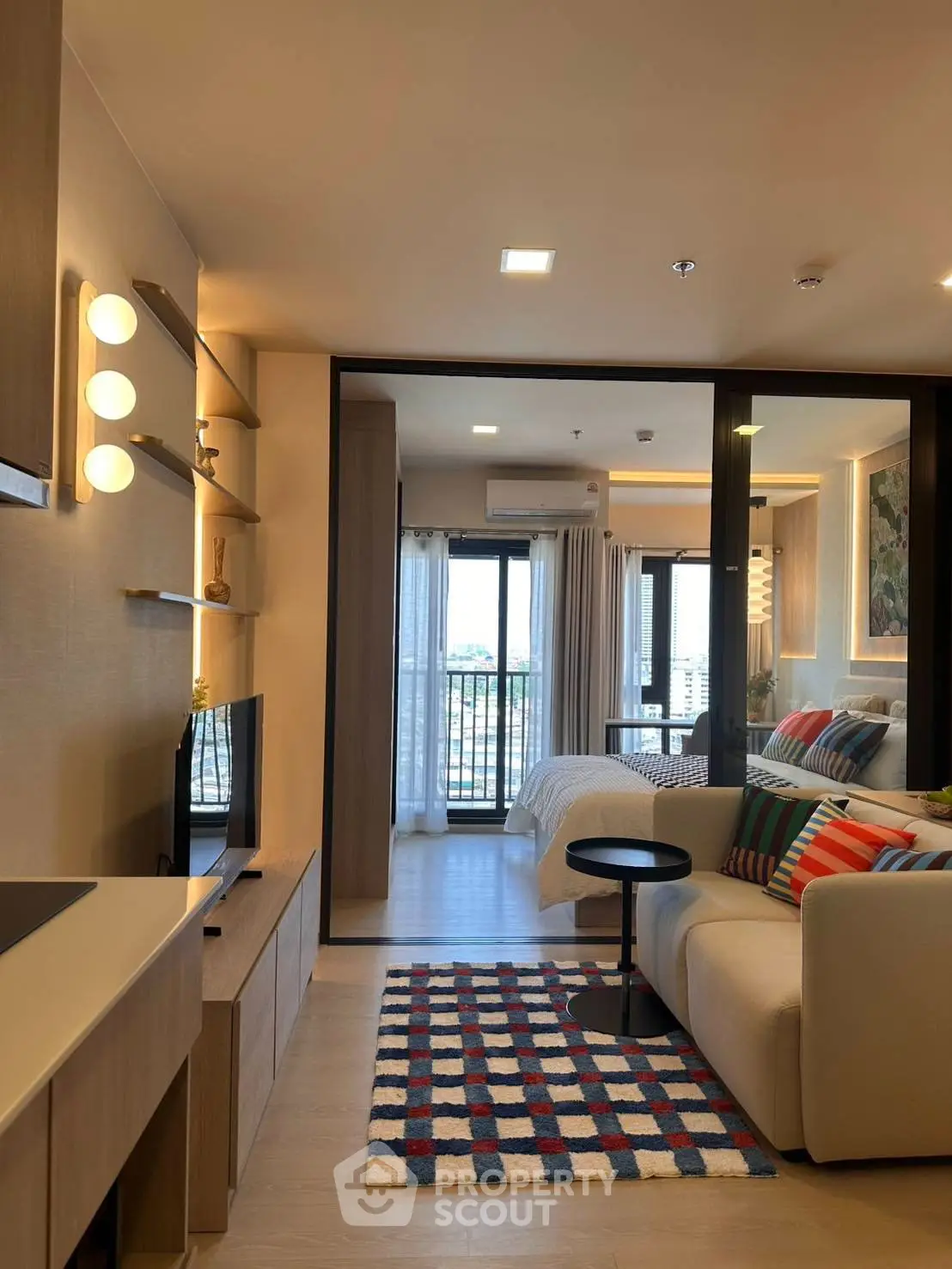 Modern open-plan living room with cozy decor and balcony view