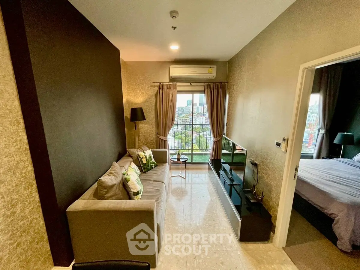 Stylish living room with modern decor and city view from balcony, adjacent to cozy bedroom.