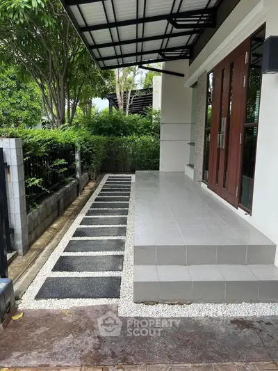 Modern home entrance with sleek tiled steps and landscaped pathway