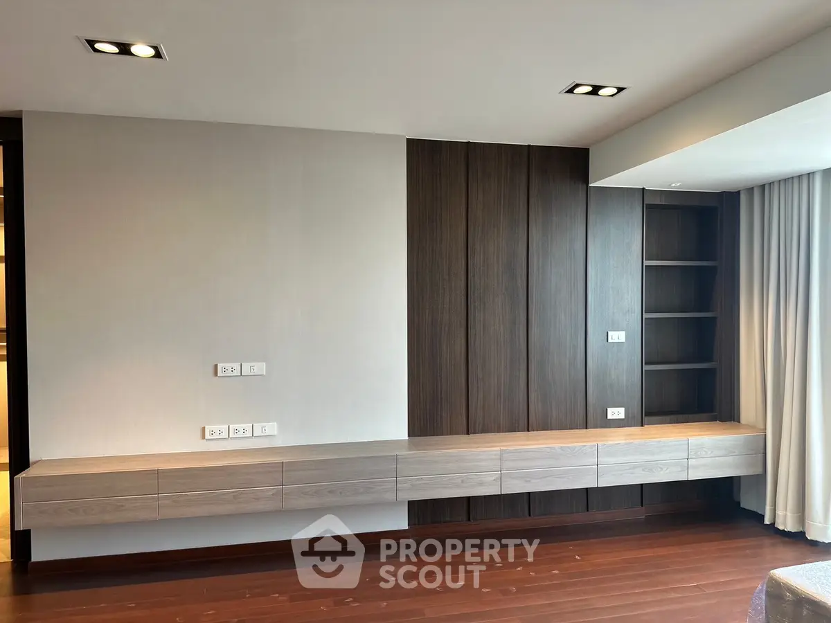 Modern living room with sleek built-in wooden shelves and elegant lighting