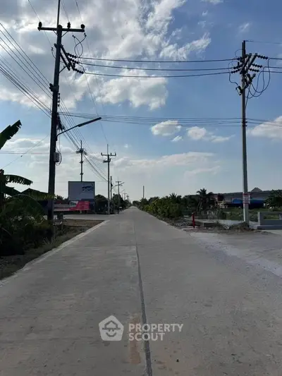 Scenic view of a quiet suburban road with clear skies and lush greenery.