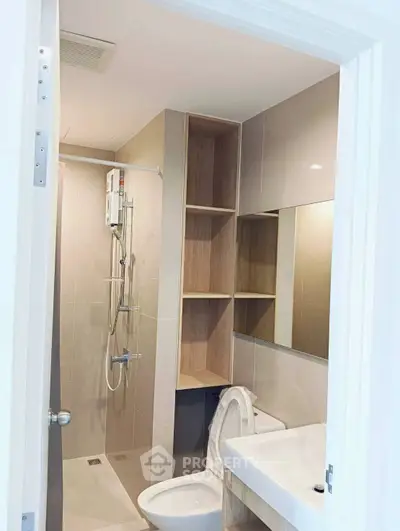 Modern bathroom with sleek shower and built-in storage in a contemporary apartment.