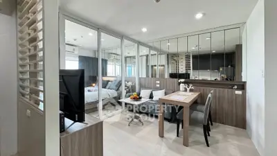Modern open-plan living room with dining area and mirrored walls enhancing space.