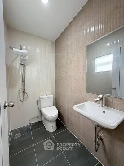 Modern bathroom with sleek fixtures and neutral tiles, perfect for a contemporary home.