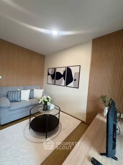 Modern living room with stylish decor and cozy seating area, featuring abstract art and wooden accents.