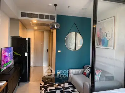 Modern living room with stylish decor and compact design, featuring a cozy sofa and wall art.