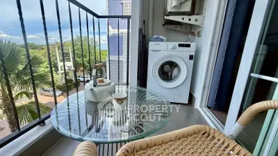 Charming balcony with washing machine and outdoor seating, perfect for relaxation.