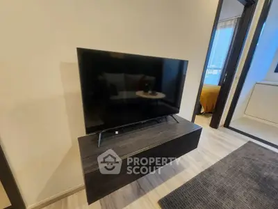 Modern living room with sleek TV stand and flat-screen TV, showcasing contemporary interior design.