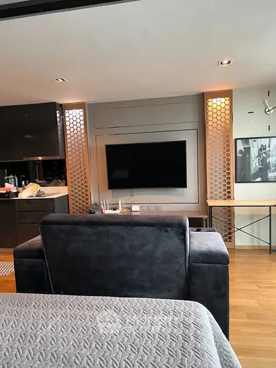 Modern living room with sleek design, featuring a wall-mounted TV and stylish decor, perfect for urban living.