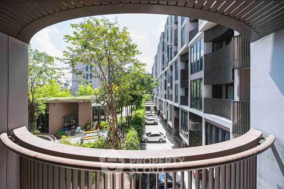Modern apartment building with lush greenery and spacious balcony view.