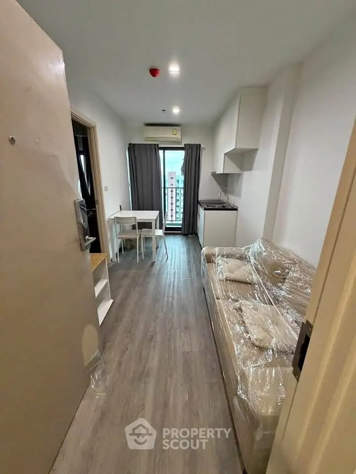 Modern studio apartment with open layout and stylish furnishings, featuring a cozy living area and compact kitchen.