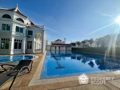 Luxurious villa with stunning outdoor pool and elegant architecture under clear blue sky.