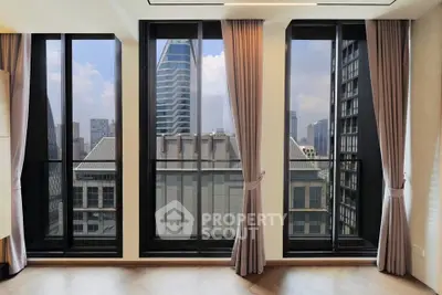 Stunning city view from modern apartment with floor-to-ceiling windows and elegant curtains.